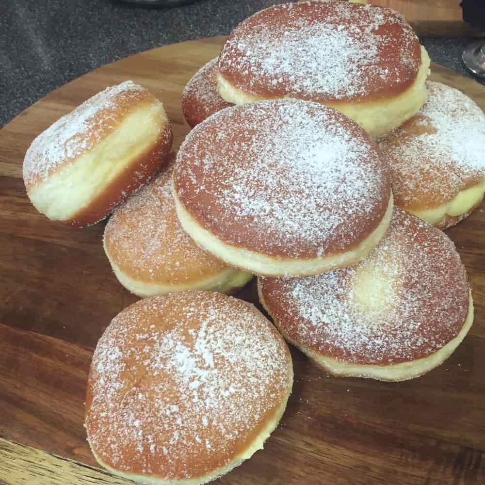 A pile of icing sugar coated Italian doughnuts - basically, without the hole!