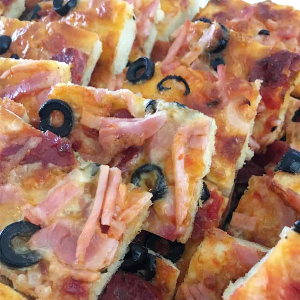 You are looking at slices of pizza with ham, olives and cheese.