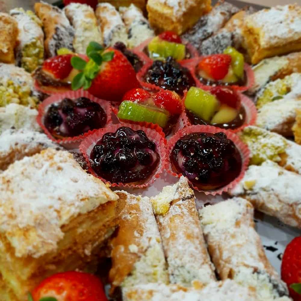 A platter of icing sugar dusted pastries.