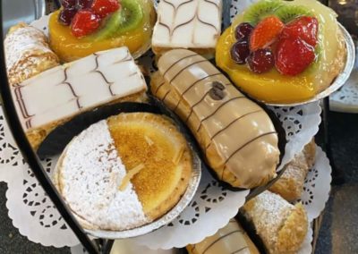 Two plates of Danishes and sweet pastries.